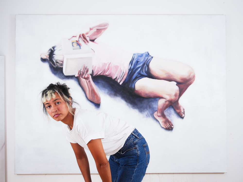 The Berlin artist Jana Jacob in front of her oil painting Die Optimisten.